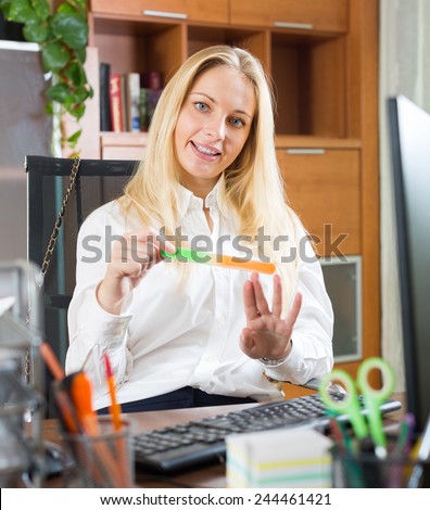 happy young woman doing manicure at office area