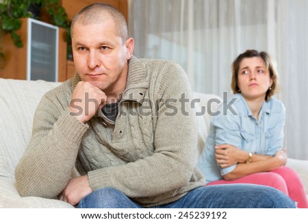 Family having conflict at home. Sadness man against unhappy young woman