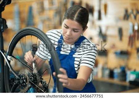 Similar – Image, Stock Photo Professional female master fixing wheel of motorbike