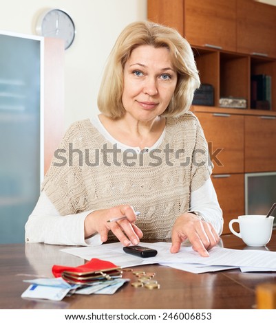 Serious  woman woman working with documents money at  table