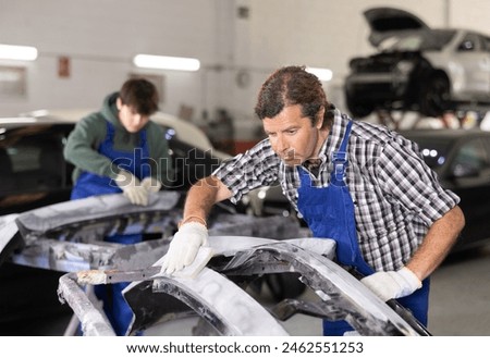 Similar – Image, Stock Photo Busy male mechanic repairing motorcycle seat in workshop