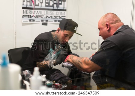 BARCELONA, SPAIN - OCTOBER 3, 2014: Professional artist  doing  tattoo on client arm. The 17th edition of The Barcelona Tattoo Expo in Fira de Barcelona