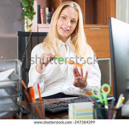 Young woman doing manicure at office area