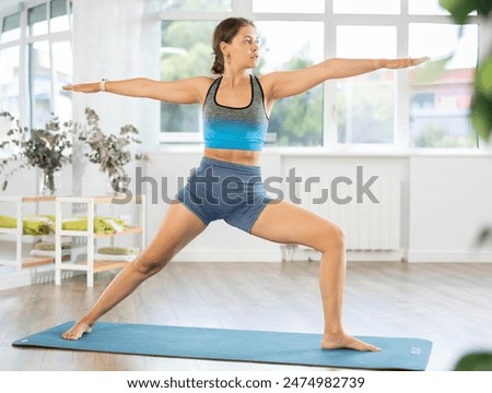 Similar – Image, Stock Photo Calm woman in Warrior pose on yoga mat