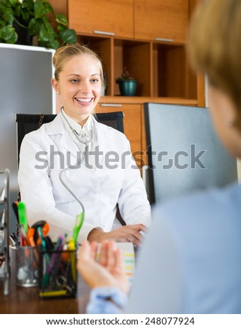 Smiling young female doctor discussing with patient his options