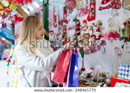 cheerful  girl shopping at festive fair before Xmas at Christmas market