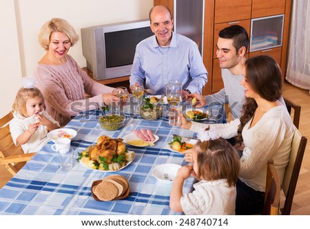 Multigenerational family sitting at the table set for dinner and talks