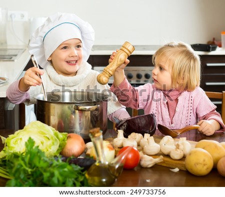 Small children cooking food in the kitchen indoors
