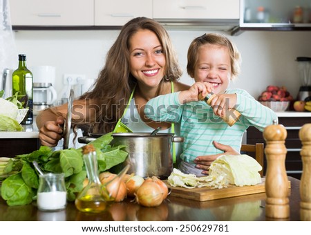 Happy young  family cooking soup  at home kitchen