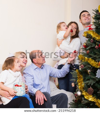 Portrait of european family decorate the Xmas tree in appartment