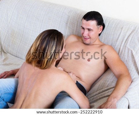 girl seducing handsome man on sofa  indoor