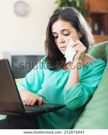 Crying  girl with laptop in living room
