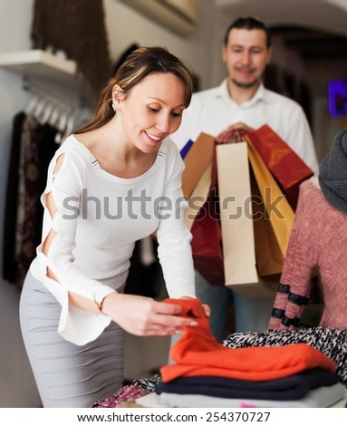 Ordinary couple choosing clothes at fashion market