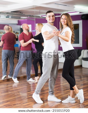 Happy adult couples enjoying of partner dance and smiling indoor