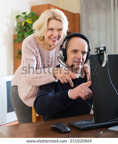 Beauty elderly couple talking with someone online and smiling