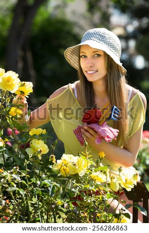 Woman florist working in the garden with blooming roses