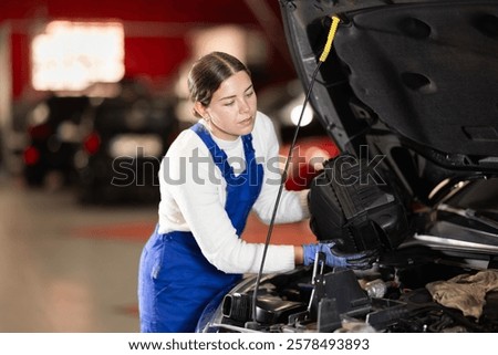 Similar – Image, Stock Photo Professional female master fixing wheel of motorbike