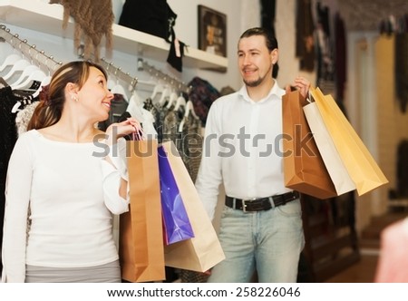 Happy houple with shop-bags at clothing store