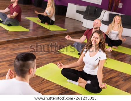european coach showing to adult learners new yoga posture at class