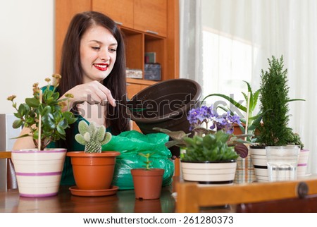 woman working with  flowers in pots at home