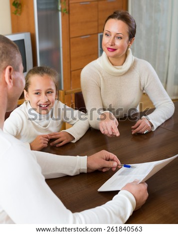 Happy family with documents at table in the living room