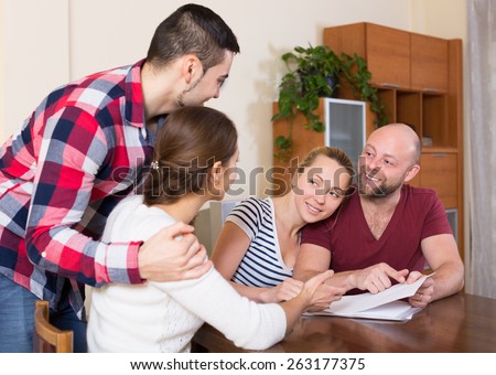 Young spouses sitting with documents and asking friends for advice