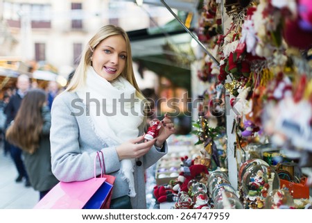 Positive beauty blonde woman shopping at festive fair before Xmas