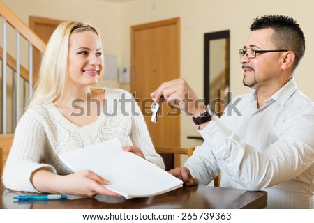 Husband and positive wife signing a contract and buying apartment