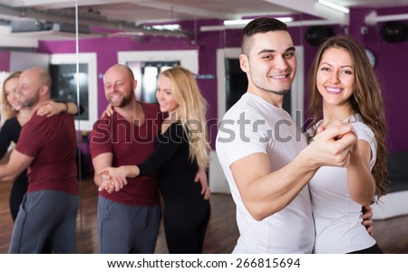 Happy young couples enjoying of partner dance and smiling indoor