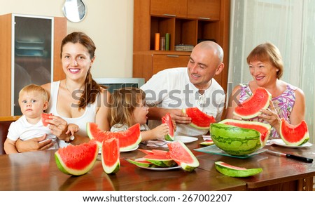 Portrait of  happy three generations family eating  melon at home