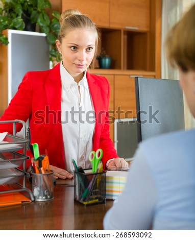 Young businesswoman having difficult conversation with employee