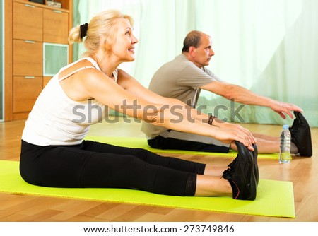 Active  pensioners doing morning exercises indoor