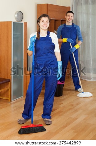 Cleaners team cleaning floor in room