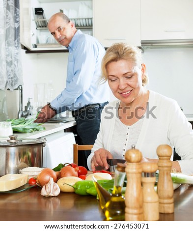elderly man and mature woman doing housework together
