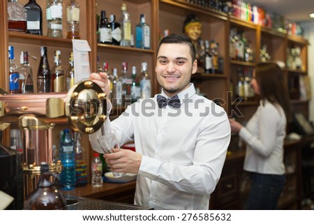 Smiling young waitress and barmen working in modern bar