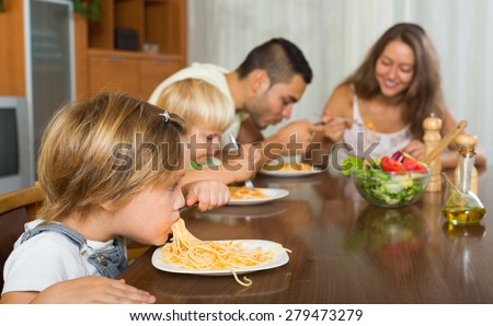 family of four  having lunch with pasta together