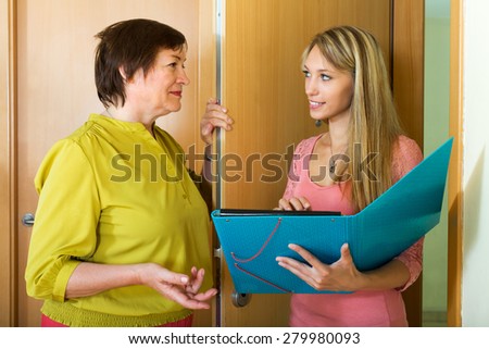 Woman answers the questions of smiling employee in door