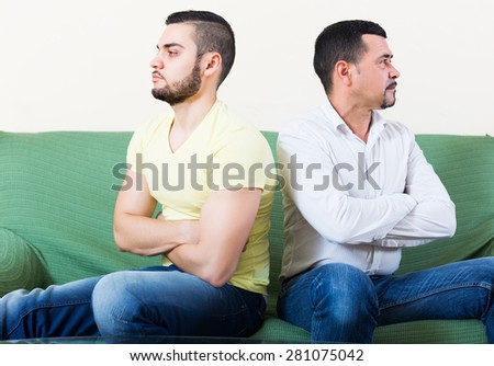 Two unhappy male adults arguing about something indoors