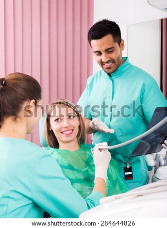 Female dentist and young patient looking x-ray scan