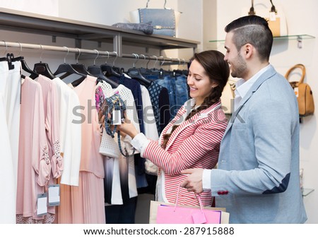 Adult spouses smiling while shopping at boutique