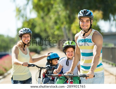 Happy family with two little daughters traveling by bicycles. Focus on man
