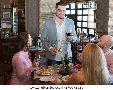 Portrait of positive young adults having dinner in family restaurant