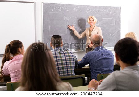 Female professor teaching class of mixed age students at refresher courses