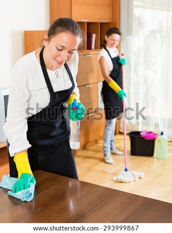 Positive adult professional cleaners woman washing apartment with rag and mop