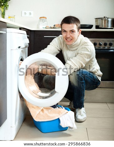 man looking  clothes near washing machine