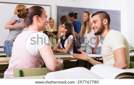 Friendly  students 25 years old chatting while sitting in the room