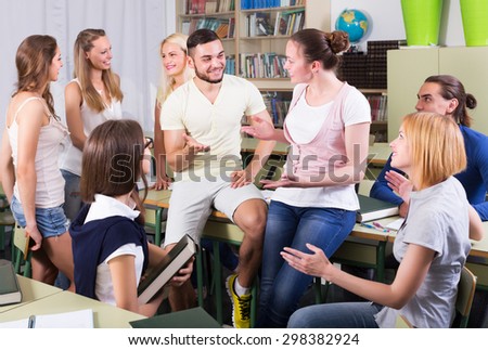Happy students having a conversation sitting in the classroom