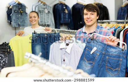 Happy couple choosing clothes at clothing shop