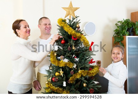 Happy family with small daughter at Christmas time or winter holiday season  at home.