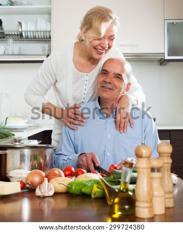 Happy vegetarian woman  smiling with senior and  cooking in domestic kitchen